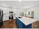Modern kitchen with stainless steel appliances, a large island, and ample cabinet space at 404 Basingdon Ct, Waxhaw, NC 28173