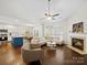 Open-concept living space with a fireplace, hardwood floors, and kitchen island with seating at 404 Basingdon Ct, Waxhaw, NC 28173