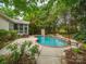 Scenic backyard with a pool, hot tub, climbing wall, and mature trees, creating a private oasis at 404 Basingdon Ct, Waxhaw, NC 28173