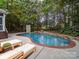 Tranquil backyard with a pool, patio, lounge chairs, and mature landscaping for ultimate relaxation at 404 Basingdon Ct, Waxhaw, NC 28173