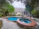 Backyard featuring a kidney-shaped pool, hot tub, patio, and well-maintained landscaping at 404 Basingdon Ct, Waxhaw, NC 28173