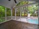 Screened-in porch with tile flooring, a view of the swimming pool and natural backyard scenery at 404 Basingdon Ct, Waxhaw, NC 28173