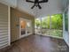 Covered porch with tile flooring, a ceiling fan, and a view of the wooded backyard at 404 Basingdon Ct, Waxhaw, NC 28173