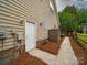 Exterior view featuring a side entrance with a well-maintained pathway and storage shed at 404 Basingdon Ct, Waxhaw, NC 28173