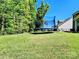 Spacious backyard featuring a trampoline, lush green grass, and a secure black fence at 413 Hunton Forest Dr, Concord, NC 28027