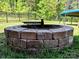 Backyard brick fire pit surrounded by green grass and partially visible trampoline at 413 Hunton Forest Dr, Concord, NC 28027