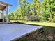 Expansive backyard featuring a patio, trampoline, lush greenery, and a fenced perimeter at 413 Hunton Forest Dr, Concord, NC 28027