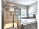 Bathroom featuring a glass door shower and tub at 413 Hunton Forest Dr, Concord, NC 28027