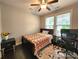Cozy bedroom featuring natural light, a ceiling fan, and a comfortable bed, creating a relaxing and private space at 413 Hunton Forest Dr, Concord, NC 28027