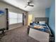 This bedroom offers plush carpet, a ceiling fan, a bright window, and unique wall accents at 413 Hunton Forest Dr, Concord, NC 28027