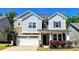 Charming two-story home featuring stone accents, gray siding, and a two-car garage at 413 Hunton Forest Dr, Concord, NC 28027