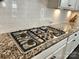 Modern stainless steel cooktop on granite countertops with white subway tile backsplash and white cabinetry at 413 Hunton Forest Dr, Concord, NC 28027