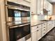 Stainless steel double oven, and white cabinets, against a white subway tile backsplash at 413 Hunton Forest Dr, Concord, NC 28027