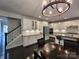 Bright and spacious kitchen with white cabinetry, granite countertops, stainless steel appliances, and staircase nearby at 413 Hunton Forest Dr, Concord, NC 28027