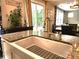 A kitchen island features a farmhouse sink and a granite countertop extending to an adjacent dining and sitting room at 413 Hunton Forest Dr, Concord, NC 28027