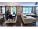 Open living room, dining room, and kitchen feature hardwood floors, large windows, and a neutral color palette at 413 Hunton Forest Dr, Concord, NC 28027