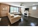 Living room with large sectional sofa, fireplace, and large windows with a ceiling fan overhead at 413 Hunton Forest Dr, Concord, NC 28027
