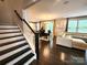 Open-concept living space featuring hardwood floors, a staircase, and abundant natural light at 413 Hunton Forest Dr, Concord, NC 28027