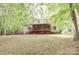 Backyard featuring a screened-in porch, spacious yard, and bordered by lush green trees at 4410 Laurel Twig Ct, Charlotte, NC 28215