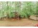 A serene backyard featuring mature trees, a playhouse, and storage shed at 4410 Laurel Twig Ct, Charlotte, NC 28215