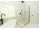 Bathroom features a soaking tub, a glass enclosed shower, modern fixtures, and white marble tile at 4410 Laurel Twig Ct, Charlotte, NC 28215