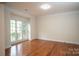 Well-lit bedroom featuring hardwood floors, crown molding, and a large window overlooking the yard at 4410 Laurel Twig Ct, Charlotte, NC 28215