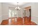 Bright dining room featuring hardwood floors, wainscoting, crown molding, and a decorative chandelier at 4410 Laurel Twig Ct, Charlotte, NC 28215