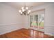 Elegant dining room featuring hardwood floors, wainscoting, crown molding, and a decorative chandelier at 4410 Laurel Twig Ct, Charlotte, NC 28215