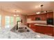 Stylish kitchen featuring granite countertops, a stainless sink and cherry cabinets with black appliances at 4410 Laurel Twig Ct, Charlotte, NC 28215