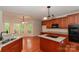 Open-concept kitchen featuring a granite island, stainless sink, cherry cabinets and access to dining area at 4410 Laurel Twig Ct, Charlotte, NC 28215