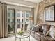 Cozy living room with balcony access, a comfortable leather couch, and a modern glass coffee table at 4625 Piedmont Row Dr # 701, Charlotte, NC 28210