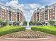 Beautiful Town Square with fountains, landscaping, and shops, surrounded by elegant buildings with balconies under a partly cloudy sky at 4625 Piedmont Row Dr # 701, Charlotte, NC 28210