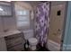 Full bathroom with vanity, toilet, and shower-tub combination with floral curtain at 515 Upper Spencer Mountain Rd, Stanley, NC 28164