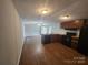 Well-lit kitchen featuring sleek wood flooring, and modern black appliances, seamlessly connecting to living area at 544 Bentley Rd, Shelby, NC 28152