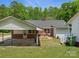 View of the home's backyard featuring a carport, brick exterior, and a well-maintained lawn at 613 W Pine St, Kershaw, SC 29067