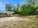 Exterior view of the property, featuring a covered carport and expansive lawn at 613 W Pine St, Kershaw, SC 29067