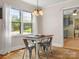 Dining area with hardwood floors, a light fixture, metal chairs, and a window with backyard view at 613 W Pine St, Kershaw, SC 29067