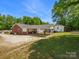 Exterior view of a home showcasing a carport and a large yard with mature trees at 613 W Pine St, Kershaw, SC 29067