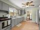 Well-lit kitchen features grey cabinets, modern appliances, ample counter space, and hardwood floors at 613 W Pine St, Kershaw, SC 29067