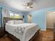 Cozy main bedroom features a large bed, hardwood floors, and soothing blue walls for a peaceful retreat at 613 W Pine St, Kershaw, SC 29067