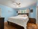 Calming main bedroom with a large bed, hardwood floors, a ceiling fan, and blue painted walls at 613 W Pine St, Kershaw, SC 29067