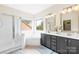 Bathroom boasts double vanity, soaking tub, glass shower, and a large window for natural light at 619 Vega Nw St, Concord, NC 28027