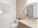 Stylish bathroom features modern fixtures, unique wallpaper, and a round mirror at 619 Vega Nw St, Concord, NC 28027