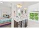 Bright bathroom with vanity, large mirror, decorative accents, and ample natural light from the window at 619 Vega Nw St, Concord, NC 28027