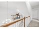 Light-filled hallway with a glimpse of the stairs, featuring wood and white railings, with fitness equipment at 619 Vega Nw St, Concord, NC 28027