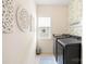 Well-lit laundry room with modern machines, decorative wall art, window, and neutral walls and flooring at 619 Vega Nw St, Concord, NC 28027