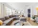 Open-concept living room with large sectional sofa, hardwood floors, and modern kitchen view at 619 Vega Nw St, Concord, NC 28027