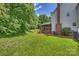 Backyard featuring green grass, trees, fence, and screened porch at 6723 Joliette Ln, Charlotte, NC 28277