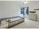 Charming bedroom with lots of light, crib, gray dresser, and ceiling fan at 6723 Joliette Ln, Charlotte, NC 28277