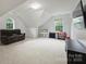 Spacious bonus room featuring neutral paint, carpet, sofa, large windows and storage at 6723 Joliette Ln, Charlotte, NC 28277